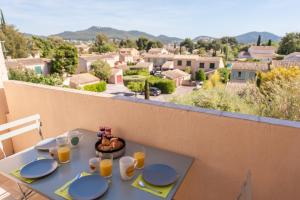 Una mesa con platos de comida en un balcón con vistas. en Studio del Sol, en Saint-Cyr-sur-Mer