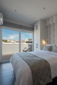ein Schlafzimmer mit einem großen Bett und einem großen Fenster in der Unterkunft 12 Keys Athens Apartments in Athen