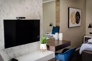 a living room with a large flat screen tv on a wall at The Royal Guest House in Klerksdorp