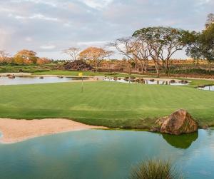 a view of a golf course with a pond at Villa Alexis - Location de vacances à Trou aux Biches in Trou aux Biches