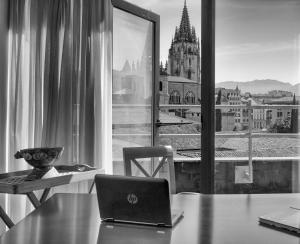 un ordenador portátil sentado en una mesa frente a una ventana en Hotel Gran Regente en Oviedo
