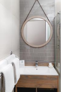 uma casa de banho com um lavatório e um espelho em Loerie Guest Lodge em George
