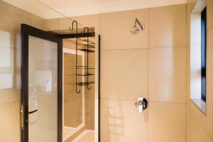 a shower with a glass door in a bathroom at Loerie Guest Lodge in George