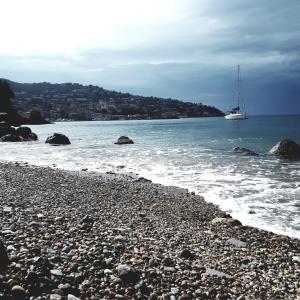 a boat in the water on a rocky beach at Bike&Boat Argentario Hotel in Porto Santo Stefano