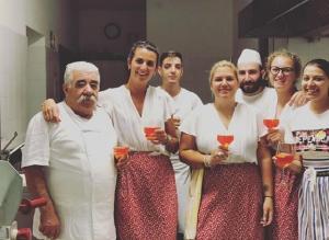 Hotel Beau Sejour Pré-Saint-Didier في حمامات بري ساينت ديدييار: مجموعة من الناس يقفون في مطبخ يحملون كؤوس النبيذ