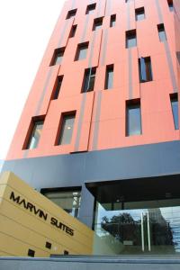 un bâtiment rouge avec un panneau devant lui dans l'établissement Marvin Suites Hotel, à Bangkok