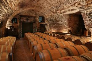 Une rangée de tonneaux de vin dans un vieux bâtiment dans l'établissement EARL DOMAINES DELMAS, à Parnac
