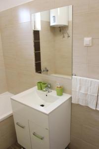 a bathroom with a white sink and a mirror at Flamingo Apartment in Sárvár