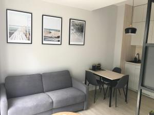 a living room with a couch and a table at Apartamenty Świnoujście - Wyspiańskiego 34e in Świnoujście