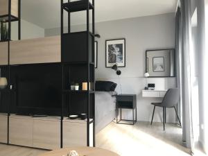 a bedroom with a loft bed with a tv and a desk at Apartamenty Świnoujście - Wyspiańskiego 34e in Świnoujście