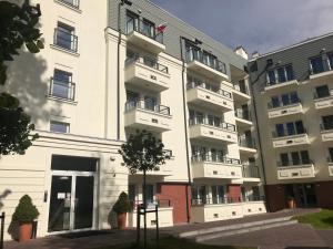 a white building with balconies on the side of it at Apartamenty Świnoujście - Wyspiańskiego 34e in Świnoujście