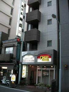 a building with a sign on the side of a street at Hotel Yanagibashi in Tokyo