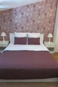 ein Schlafzimmer mit einem großen Bett mit zwei Nachttischen in der Unterkunft Apartments Serenity in Supetar