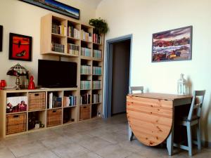 a room with a desk and a tv and book shelves at Ortigia House in Syracuse