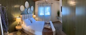 a bedroom with a large white bed with mirrors on the wall at Iliovasilema in Platy