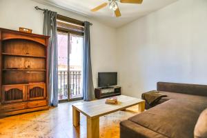 a living room with a couch and a tv at Basic Platja in Barcelona