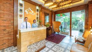 a man and woman standing at a counter in a salon at Sweet Home Boutique Hotel in Tagbilaran City