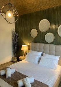 a bedroom with a large white bed with towels on it at Iliovasilema in Platy