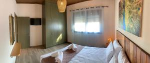a bedroom with a large bed with a window and a window at Iliovasilema in Platy