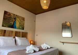 a bedroom with a bed with a peacock painting on the wall at Iliovasilema in Platy