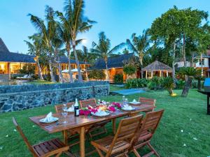 a wooden table with chairs in a yard at Mannao Estate by Villa Finder in Kerobokan +67 photos