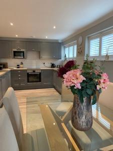 a kitchen with a vase of flowers on a table at The Barn House in Cranleigh