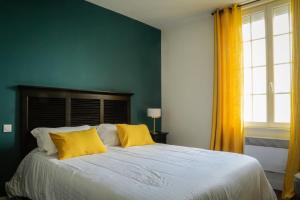 a bedroom with a large bed with yellow pillows at LE PATIO DE CLARA in Le Touquet-Paris-Plage