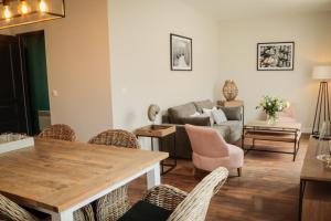 a living room with a table and chairs and a couch at LE PATIO DE CLARA in Le Touquet-Paris-Plage