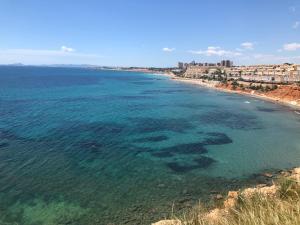 - une vue aérienne sur une plage avec des récifs dans l'eau dans l'établissement Cabo Roig - Blue Luxury Apartment, à Cabo Roig