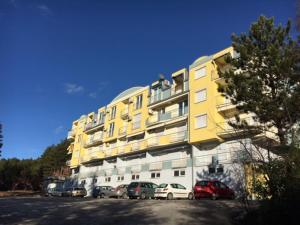 a yellow building with cars parked in front of it at Between the lake and the forest in Ohrid +19 photos