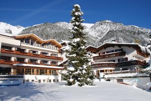 um hotel na neve com uma árvore de Natal em Hotel Gridlon em Pettneu am Arlberg