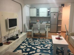 a kitchen and living room with a table and a television at Between the lake and the forest in Ohrid