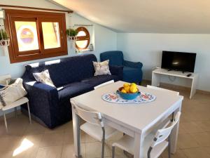 a living room with a couch and a table with a bowl of fruit at Marzamemi Centro Storico in Marzamemi