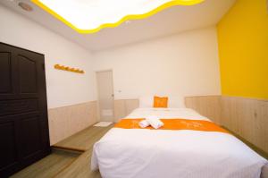 墾丁的住宿－墾丁南海旅店，卧室设有一张白色大床和黄色的墙壁