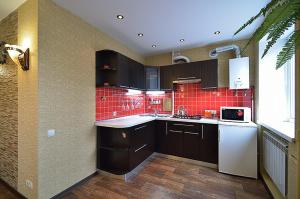 eine Küche mit schwarzen Schränken und roten Fliesen in der Unterkunft Квартира на пр. Яворницкого in Dnipro