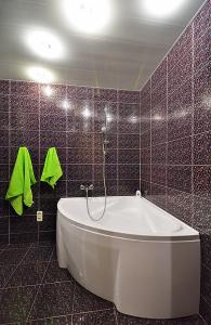 baño con bañera y pared de azulejos en Квартира на пр. Яворницкого, en Dnipro
