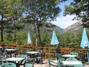 a bunch of tables and chairs with umbrellas at B&B Partenza Funivia in Lecco