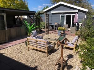 un patio con sillas, una mesa y una parrilla en bungalow Onder de iep en Ermelo