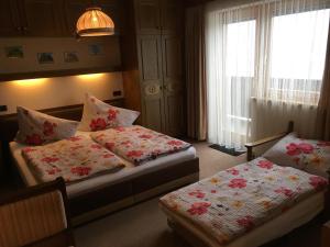 a hotel room with two beds and a window at Haus Falger in Berwang