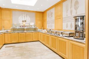 a kitchen with wooden cabinets and a counter top at Ringhotel Teutoburger Wald in Tecklenburg