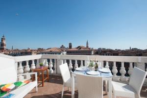 a table and chairs on a balcony with a view of the city at Ve-nice Suite Rialto View RT-12 in Venice