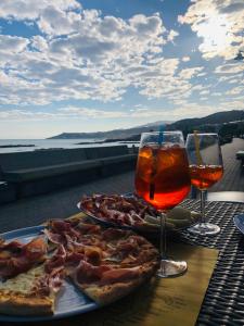 twee pizza's op een tafel met twee glazen wijn bij KAMBUSA - Mono Fronte Mare in Santo Stefano al Mare