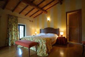 a bedroom with a bed and a chair and two lamps at Domus Cariana in San Pietro in Cariano