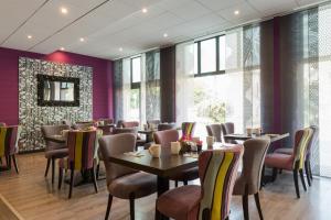 a restaurant with tables and chairs and purple walls at Relais St Eloi, Sure Hotel Collection by Best Western in Tours