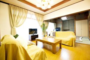 Sala de estar con 2 camas y mesa en Gunma House, en Maebashi