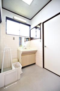 W łazience znajduje się umywalka i lustro. w obiekcie Gunma House w mieście Maebashi