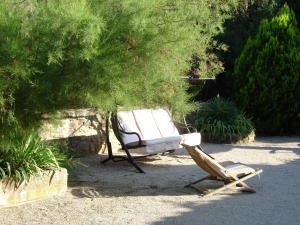 - une balançoire et une chaise dans le jardin dans l'établissement MAS SOLIGE, à Carpentras