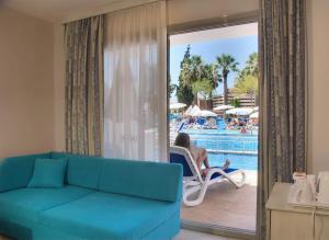 a living room with a couch and a pool at Ephesia Holiday Beach Club in Kuşadası