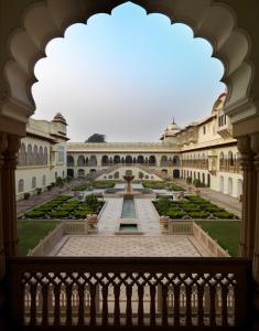 a courtyard of a building with a fountain at Rambagh Palace in Jaipur