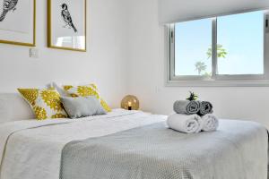 ein weißes Schlafzimmer mit 2 Betten und einem Fenster in der Unterkunft Phaedrus Living: Seaside Luxury Flat Lighthouse 67 in Paphos City